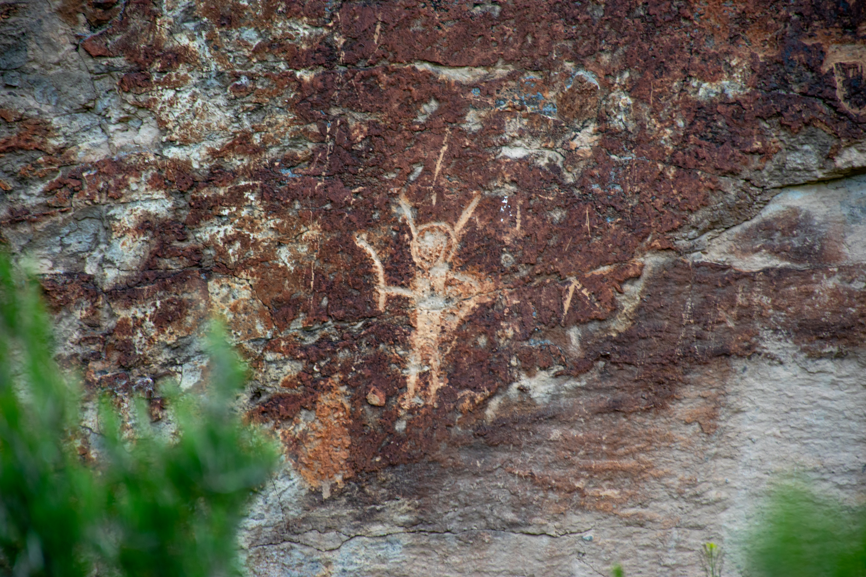 A humanoid figure drawing on a rock wall